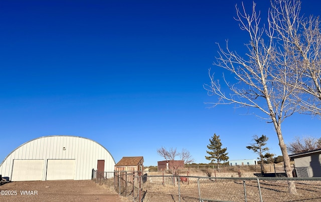 view of yard featuring a detached garage, fence, and an outdoor structure