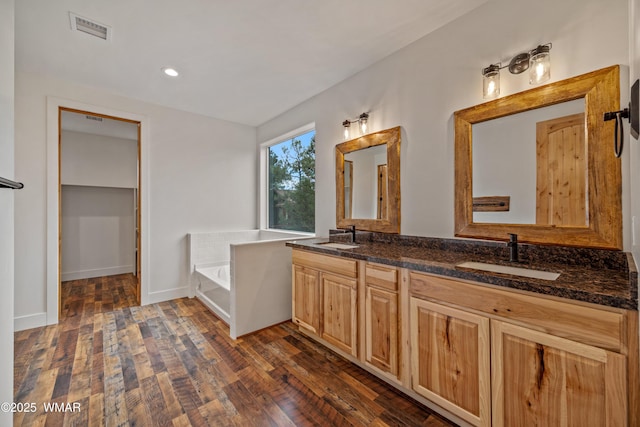 2759 Panther Cir, Overgaard, AZ 85933 - bathroom featuring wood finished floors, double vanity, a bath, recessed lighting, and baseboards