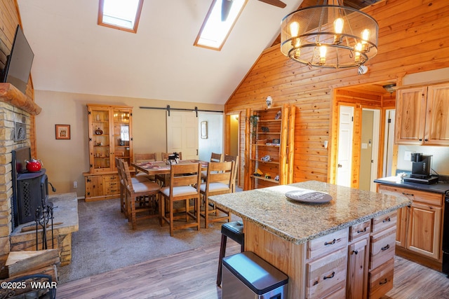 kitchen featuring a barn door, a kitchen island, pendant lighting, and light brown cabinetry