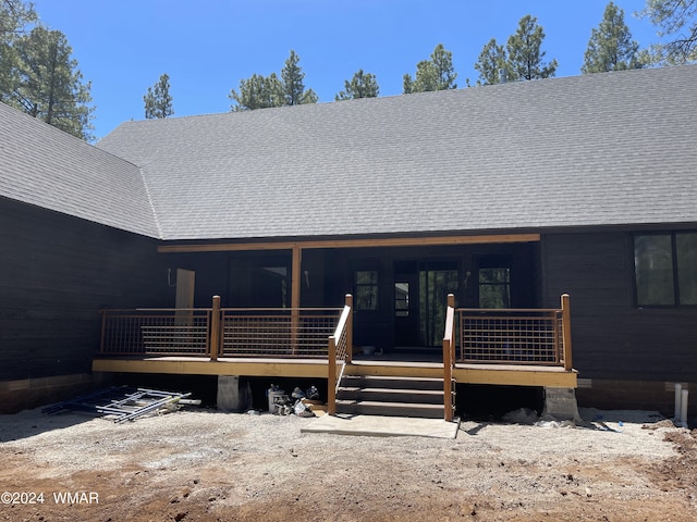 entrance to property with a shingled roof