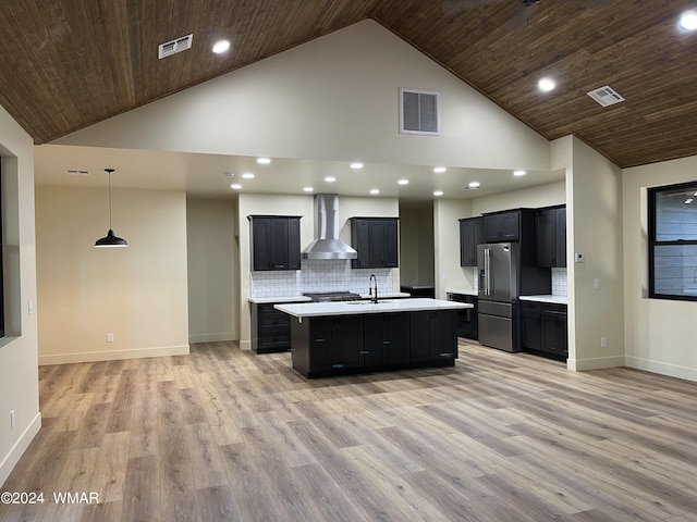 kitchen with wall chimney exhaust hood, high end fridge, light countertops, and visible vents