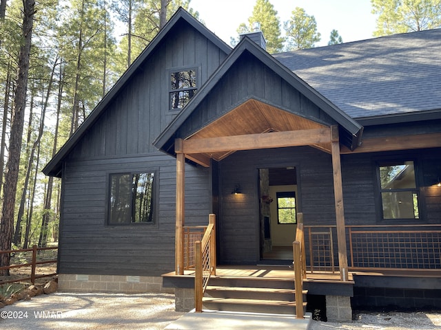 view of front facade featuring crawl space, covered porch, a shingled roof, and fence