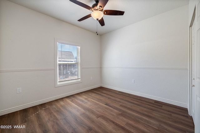 empty room featuring dark wood finished floors, a ceiling fan, and baseboards