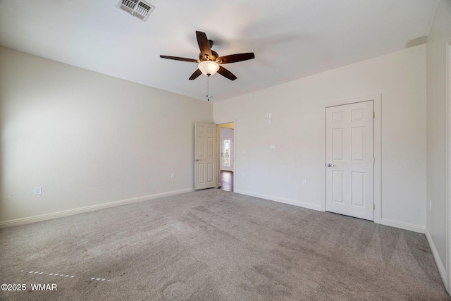 carpeted empty room featuring a ceiling fan, visible vents, and baseboards