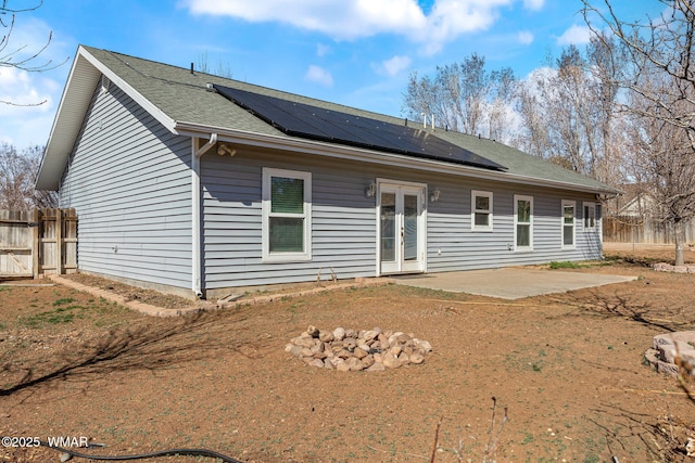 back of house featuring solar panels, french doors, a patio area, and fence