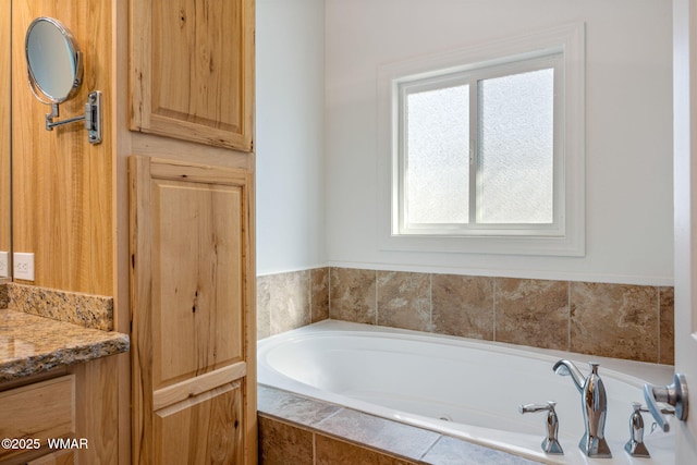 bathroom featuring vanity and a bath