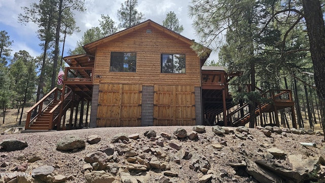 rear view of house with stairway and a wooden deck