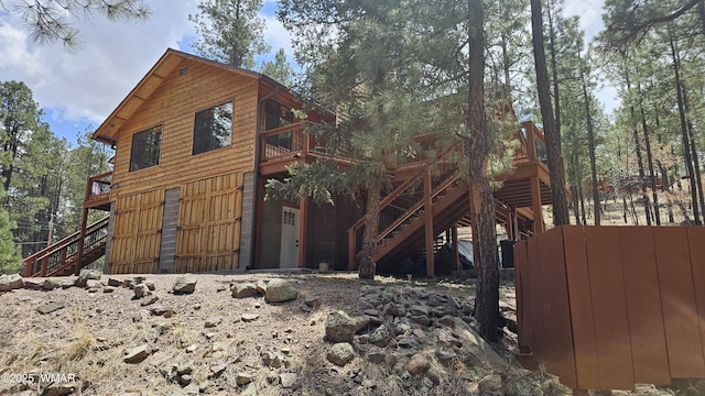 view of side of property featuring stairs and a deck