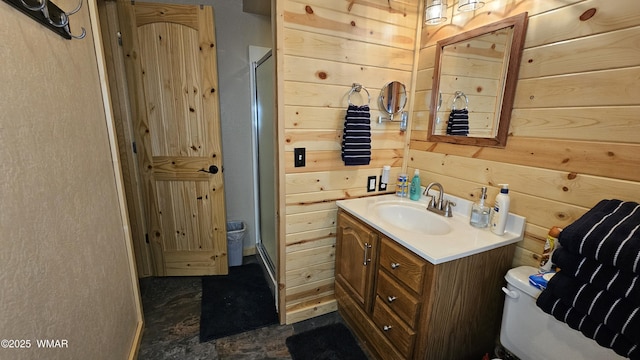 full bath with a shower stall, wooden walls, vanity, and toilet