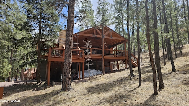 rear view of property with stairs and a deck