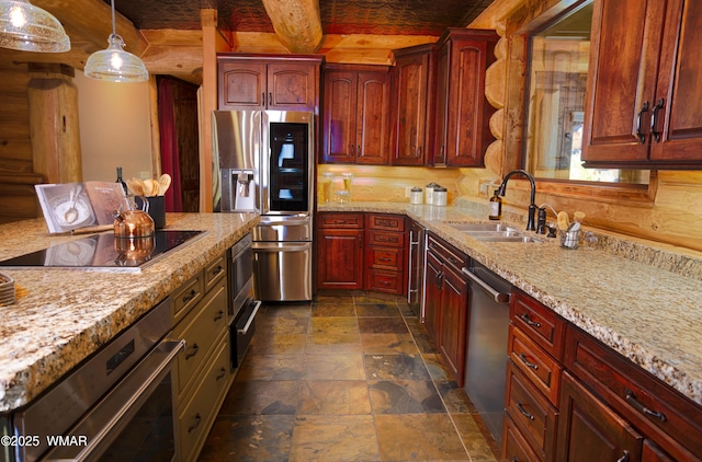 kitchen with light stone counters, decorative light fixtures, stone finish flooring, stainless steel appliances, and a sink