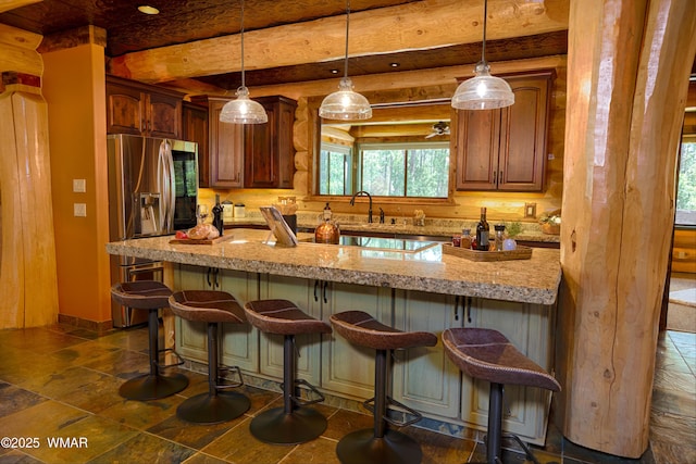 kitchen featuring pendant lighting, a peninsula, light stone counters, and a kitchen breakfast bar