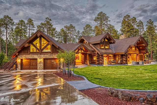 cabin featuring cooling unit, concrete driveway, stone siding, a front lawn, and a chimney