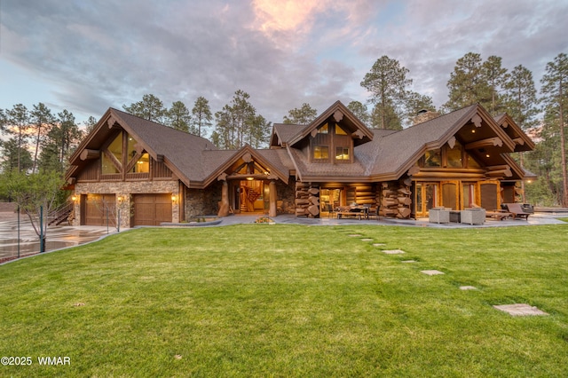 cabin with an attached garage, stone siding, and a front yard