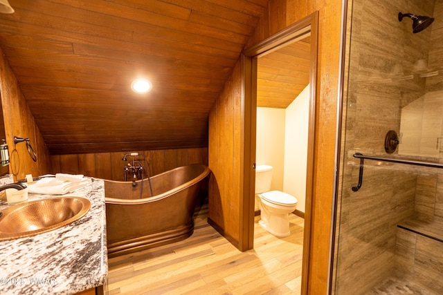 bathroom featuring toilet, a soaking tub, lofted ceiling, wood finished floors, and a shower stall