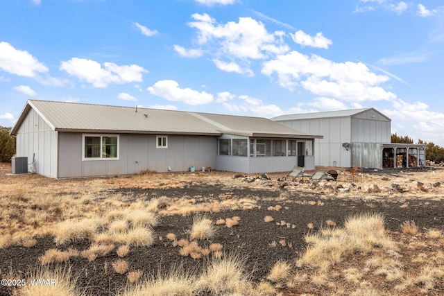 back of property with a sunroom, metal roof, and cooling unit