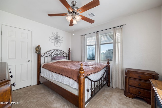 bedroom featuring visible vents, ceiling fan, and light carpet