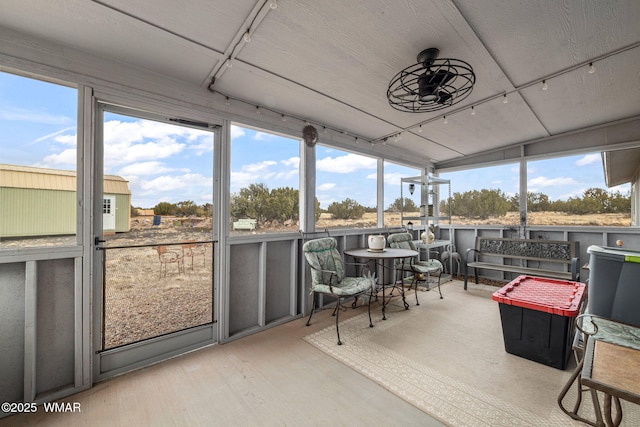 sunroom / solarium with a ceiling fan