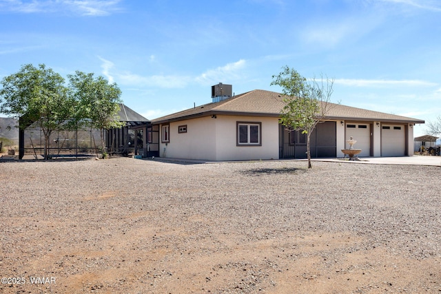 ranch-style home with concrete driveway, central air condition unit, and a garage