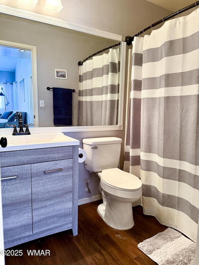 full bathroom featuring toilet, wood finished floors, and vanity