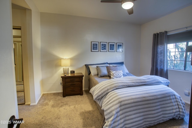 bedroom featuring light carpet, ceiling fan, and baseboards