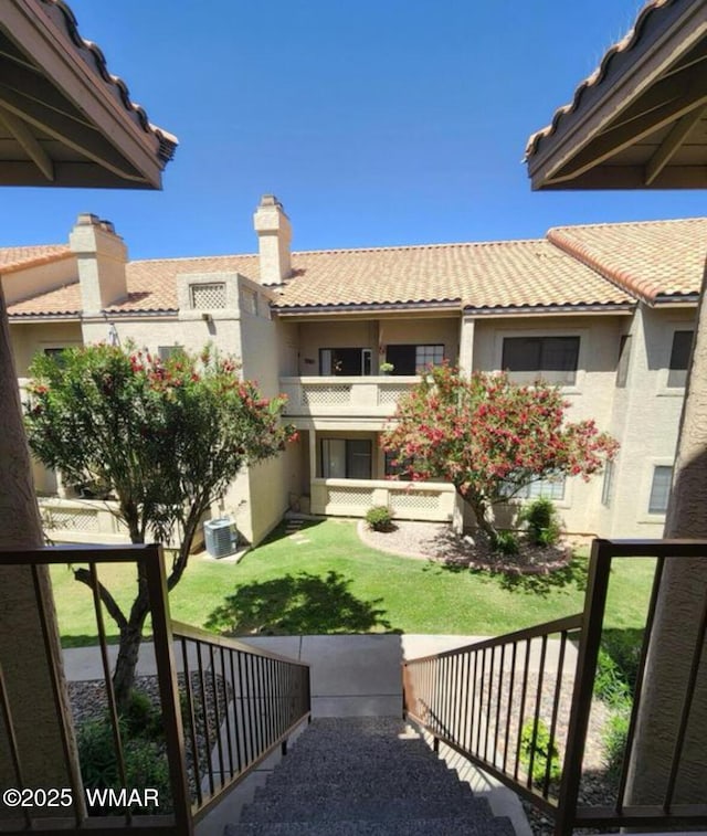 view of yard featuring a balcony and central air condition unit