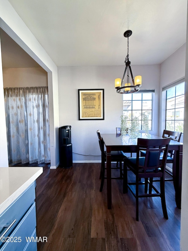 dining room featuring baseboards, dark wood finished floors, and a chandelier