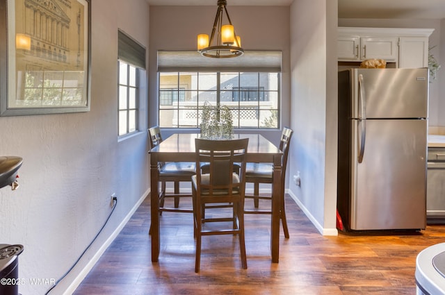 dining space with plenty of natural light, baseboards, and wood finished floors