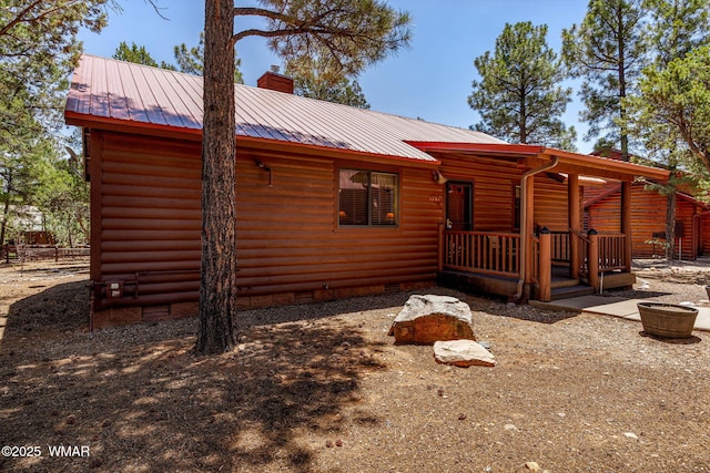 1761 N Bison Ct, Show Low, AZ 85901 - view of side of home featuring crawl space, a chimney, faux log siding, and a metal roof