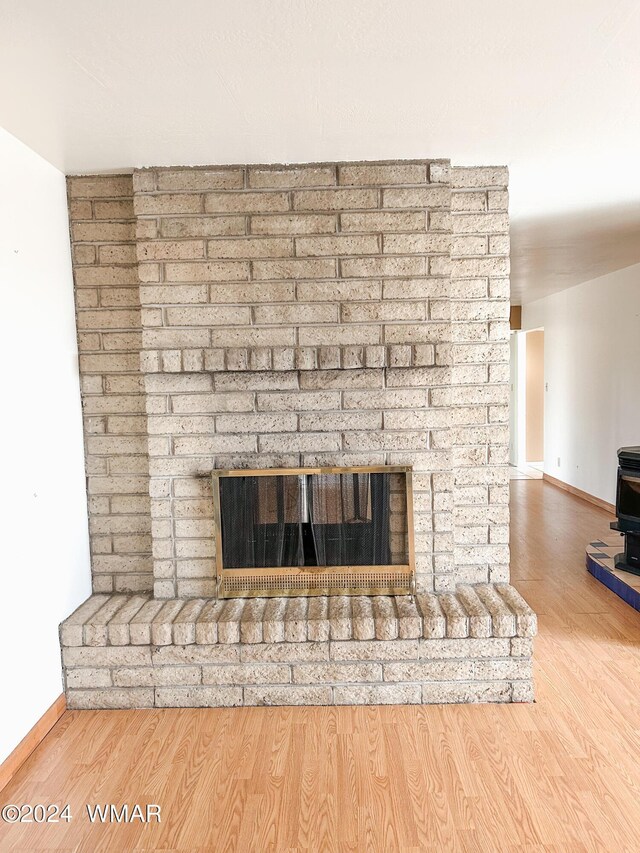 details with a brick fireplace, baseboards, and wood finished floors