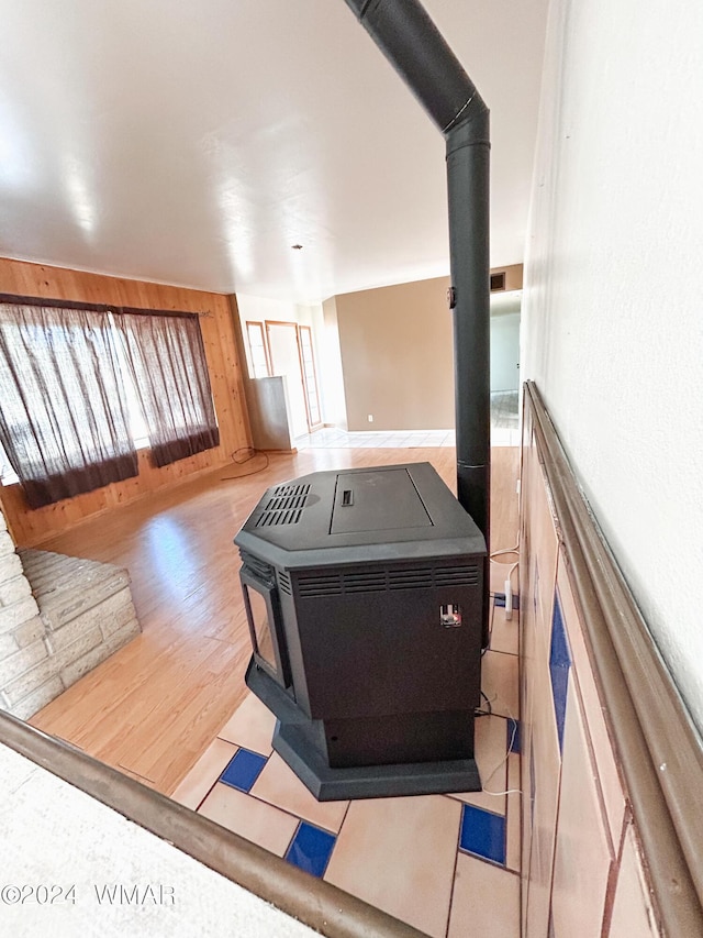 interior space featuring wood walls, wood finished floors, and a wood stove