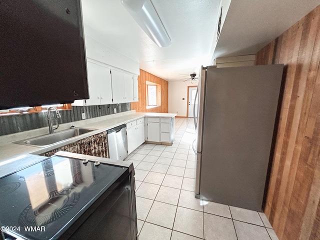 kitchen with light tile patterned floors, appliances with stainless steel finishes, light countertops, white cabinetry, and a sink