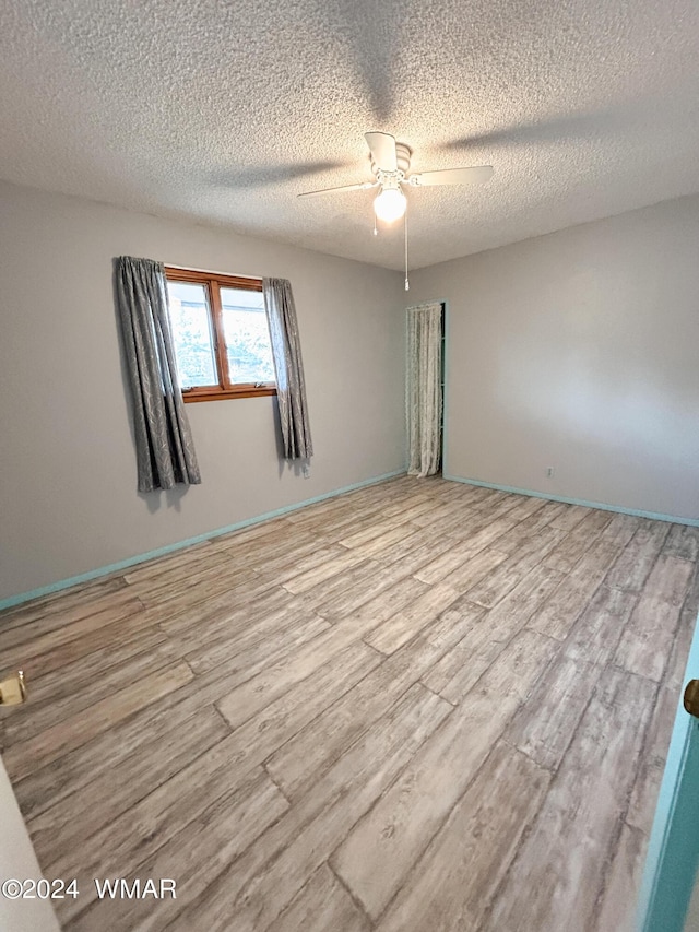 unfurnished room featuring light wood-style flooring, baseboards, and a ceiling fan