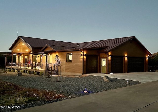 2344 Hellcat Cir, Overgaard, AZ 85933 - view of front facade featuring covered porch, a standing seam roof, a metal roof, concrete driveway, and an attached garage