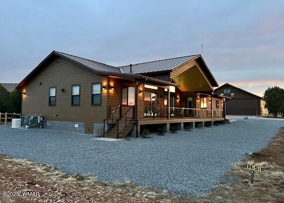 2344 Hellcat Cir, Overgaard, AZ 85933 - back of house at dusk with a metal roof and a standing seam roof