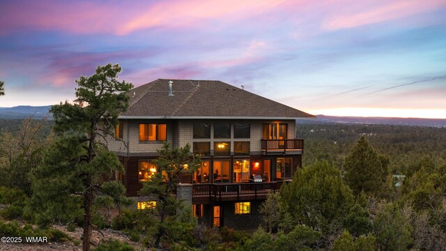 1511 S Canyon Ridge Trl, Show Low, AZ 85901 - back of house at dusk with a balcony and a wooded view
