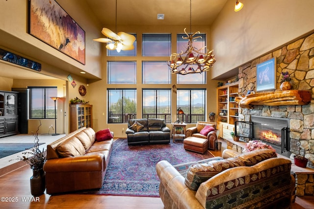 1511 S Canyon Ridge Trl, Show Low, AZ 85901 - living area featuring a stone fireplace, wood finished floors, plenty of natural light, a chandelier, and a high ceiling