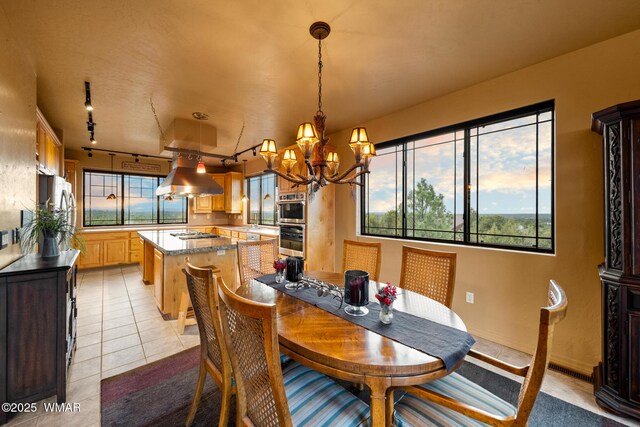 1511 S Canyon Ridge Trl, Show Low, AZ 85901 - dining space featuring a chandelier, light tile patterned floors, healthy amount of natural light, and rail lighting