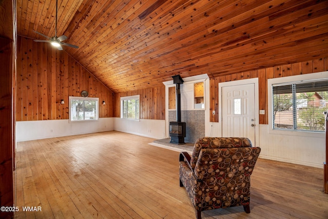3510 Sunset Ln, Lakeside, AZ 85929 - living room with wooden walls, a wood stove, lofted ceiling, a ceiling fan, and wood-type flooring