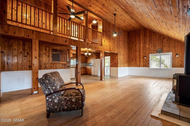 3510 Sunset Ln, Lakeside, AZ 85929 - living room with a wood stove, ceiling fan, wooden walls, wooden ceiling, and hardwood / wood-style floors