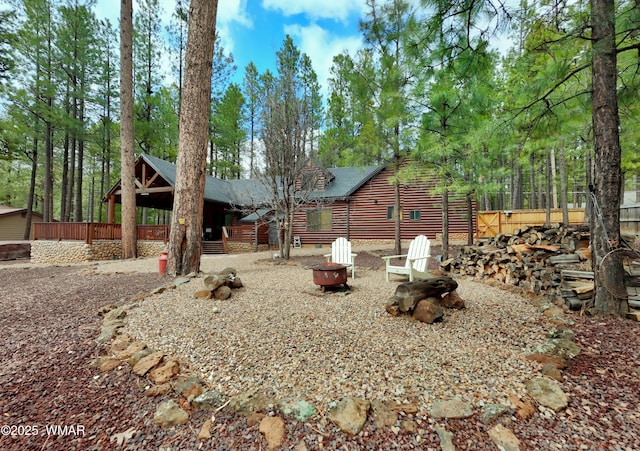 view of yard with a fire pit and fence