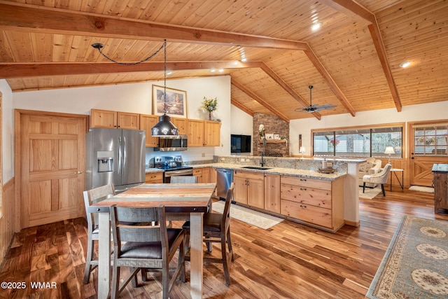 kitchen featuring pendant lighting, appliances with stainless steel finishes, light brown cabinets, a sink, and a peninsula