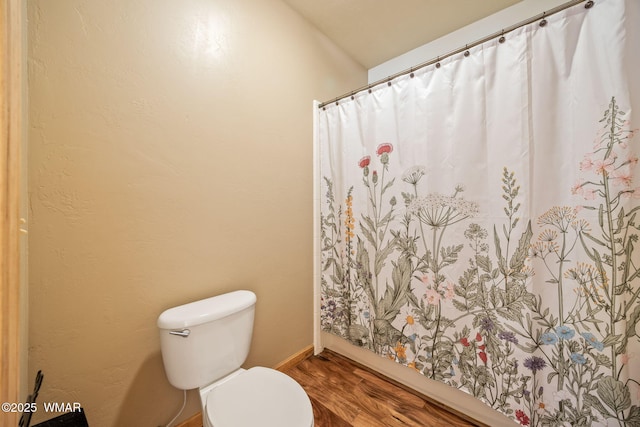 bathroom featuring baseboards, toilet, and wood finished floors