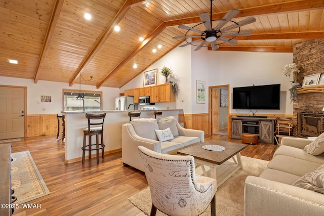 living room featuring wooden ceiling, beam ceiling, light wood-style floors, and wainscoting