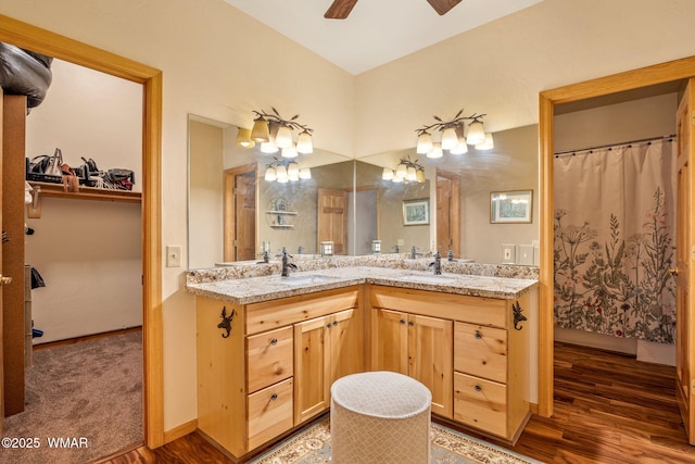 full bathroom with wood finished floors, vanity, and a ceiling fan