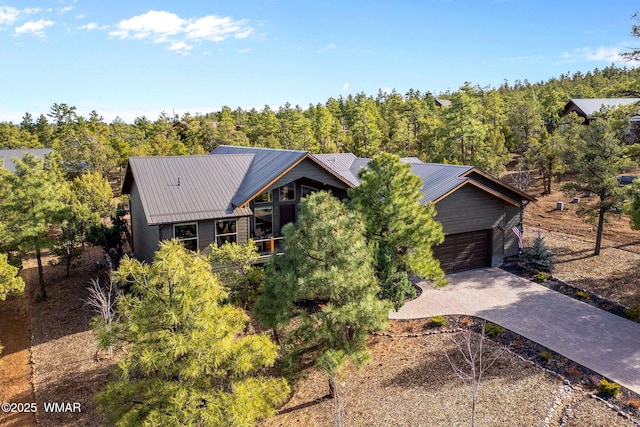 view of front of property featuring a garage, metal roof, and decorative driveway