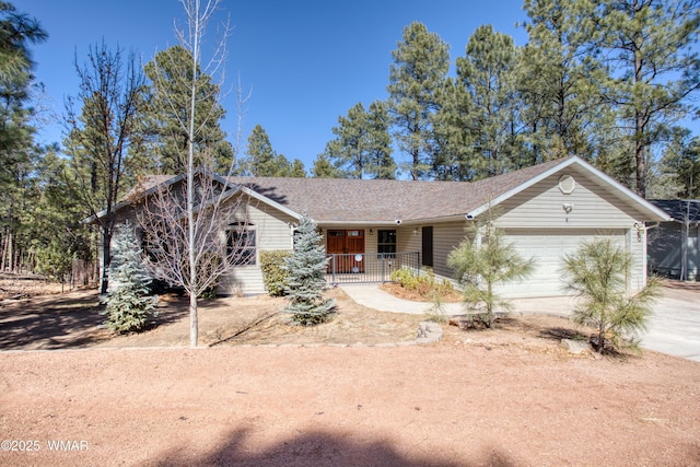 ranch-style house featuring a porch, roof with shingles, driveway, and an attached garage