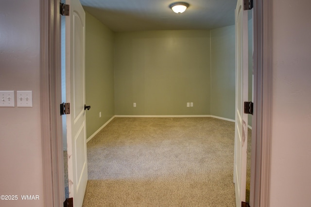 carpeted spare room featuring baseboards