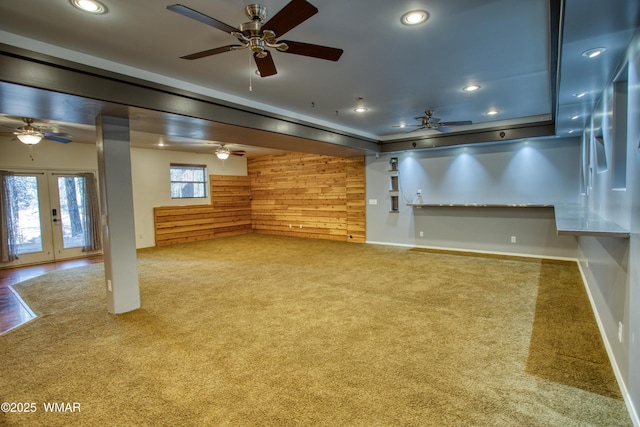 unfurnished living room with wooden walls, carpet flooring, and recessed lighting