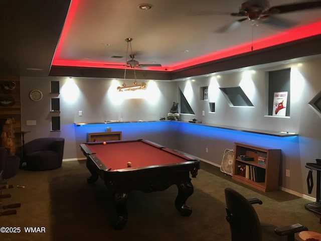 rec room with carpet floors, a raised ceiling, and baseboards